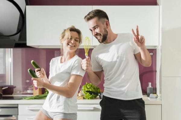 casal cozinhando feliz