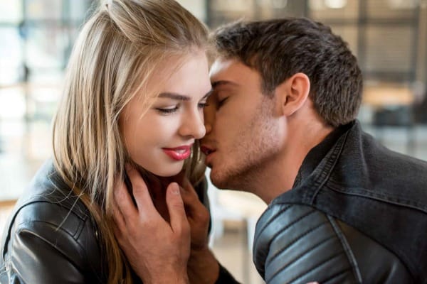 homem beijando rosto de mulher